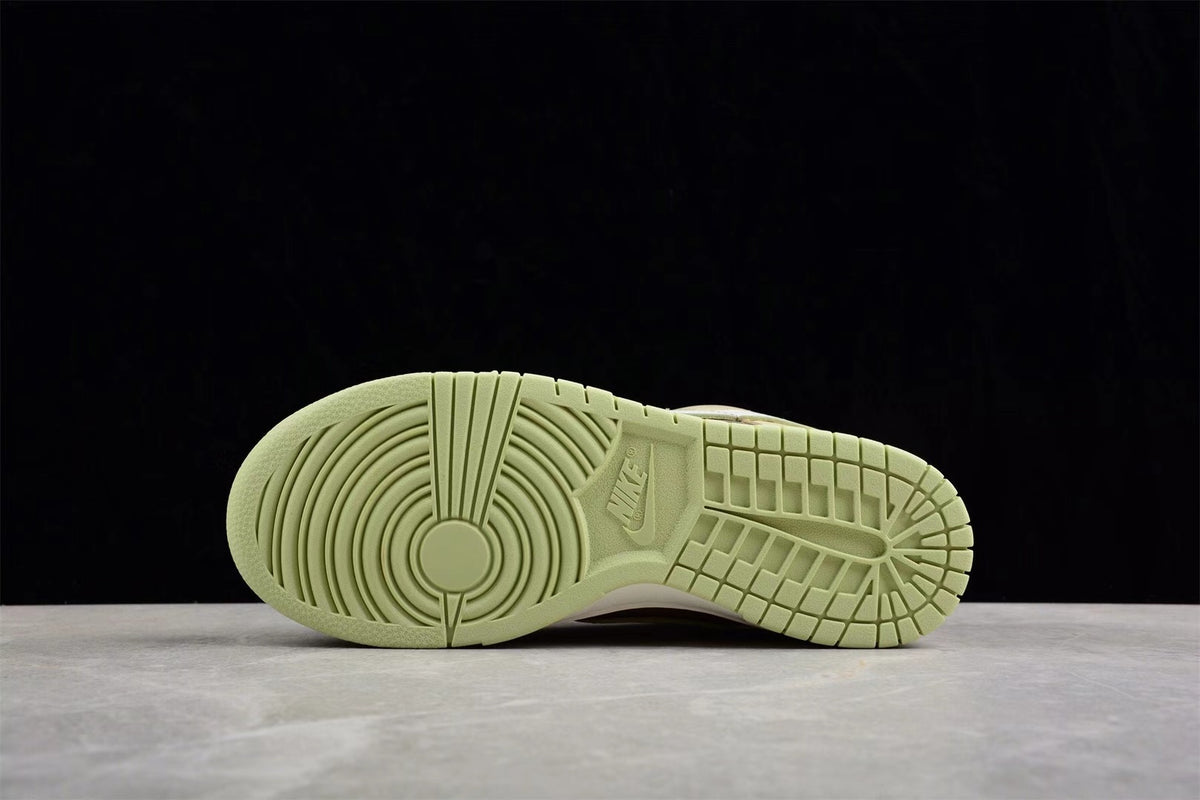 Bottom view showing the light green outsole with circular forefoot and grid-pattern traction.