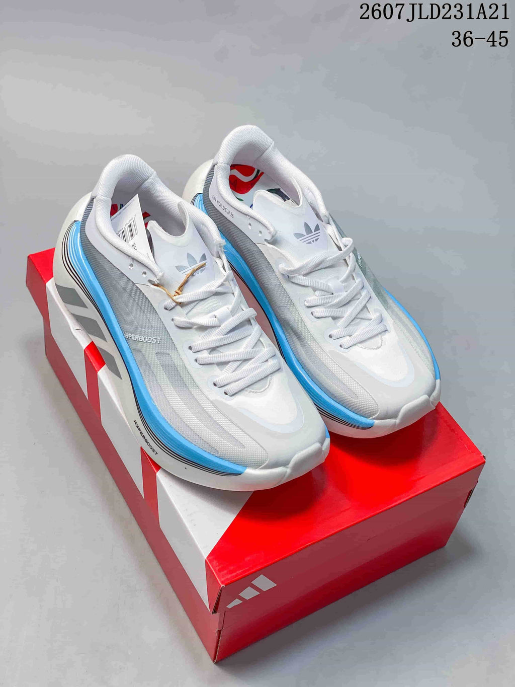Pair of white and light blue Adidas Hyperboost Edge sneakers displayed on a red Adidas shoebox.