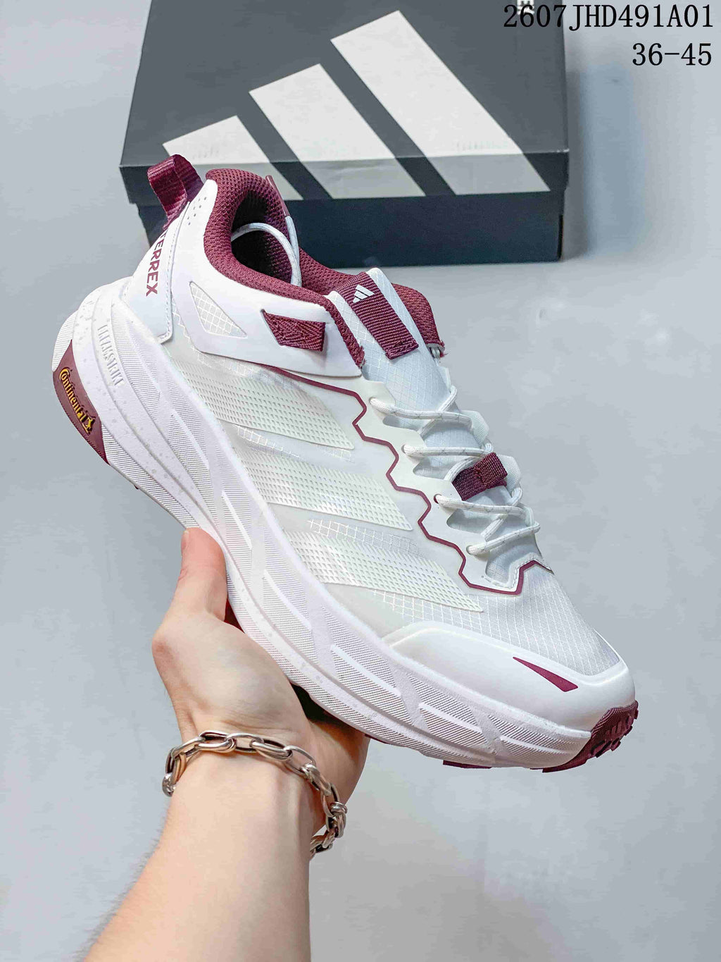 White Adidas Terrex low-top shoe with burgundy accents and a sculpted sole; image also displays the size range 36–45.