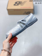 Side view highlighting the low-profile shape, layered panels, laces, and dark sole.