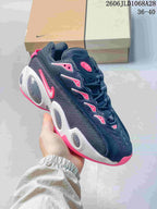 Angled side view of the black sneaker with white and pink accents