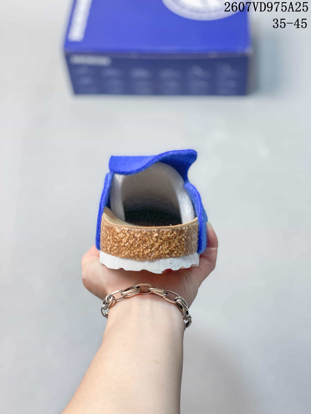 Rear view of a blue clog showing the tan cork-colored heel detail and white outsole.
