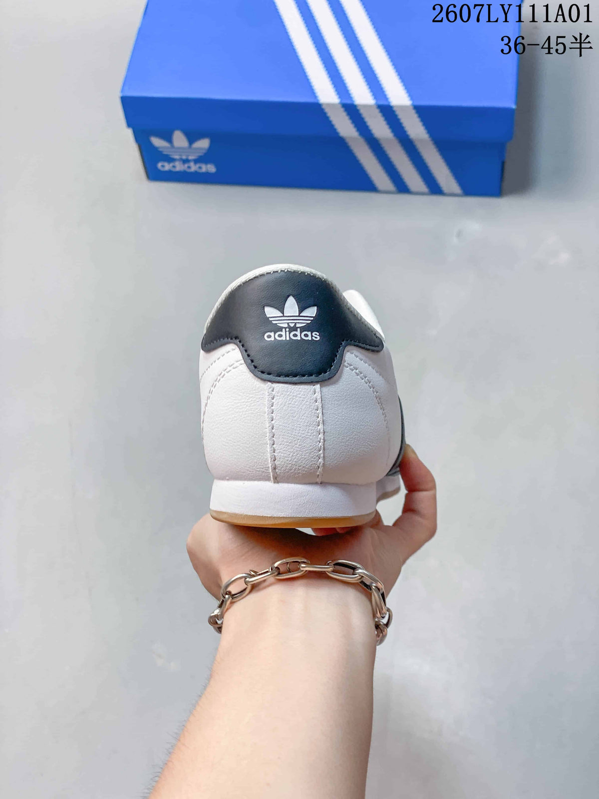 Rear view of the white shoe with a dark heel tab and Adidas Trefoil branding.