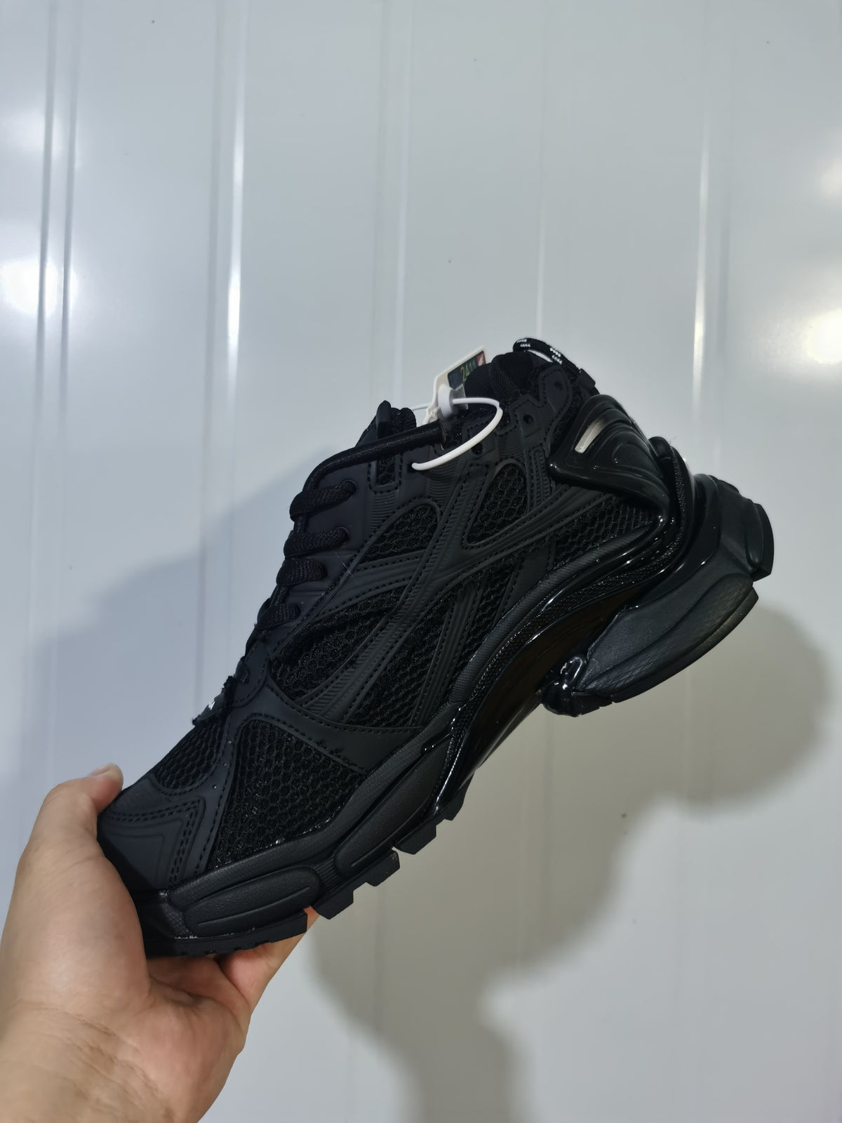 Angled rear-side view of the black matte Balenciaga Runner sneaker showing its layered upper and sculpted heel and outsole.