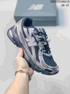 Black and silver New Balance 740 sneaker with a dark upper and contrasting overlays.