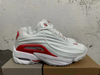 Side view showing the sculpted panels and red accents on a white sneaker