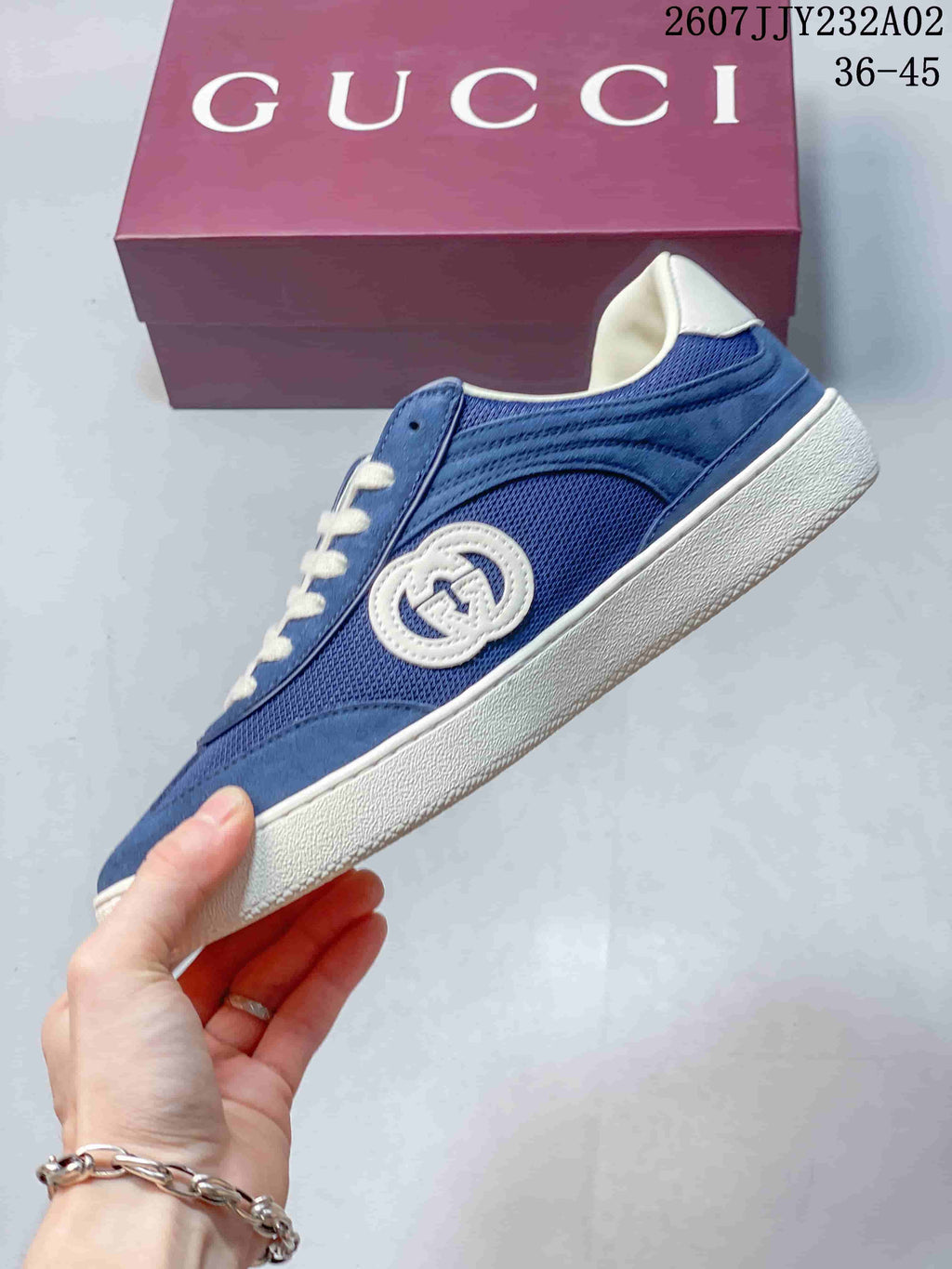 Side view of a blue sneaker with mesh panels, suede-look overlays, and embroidered emblem