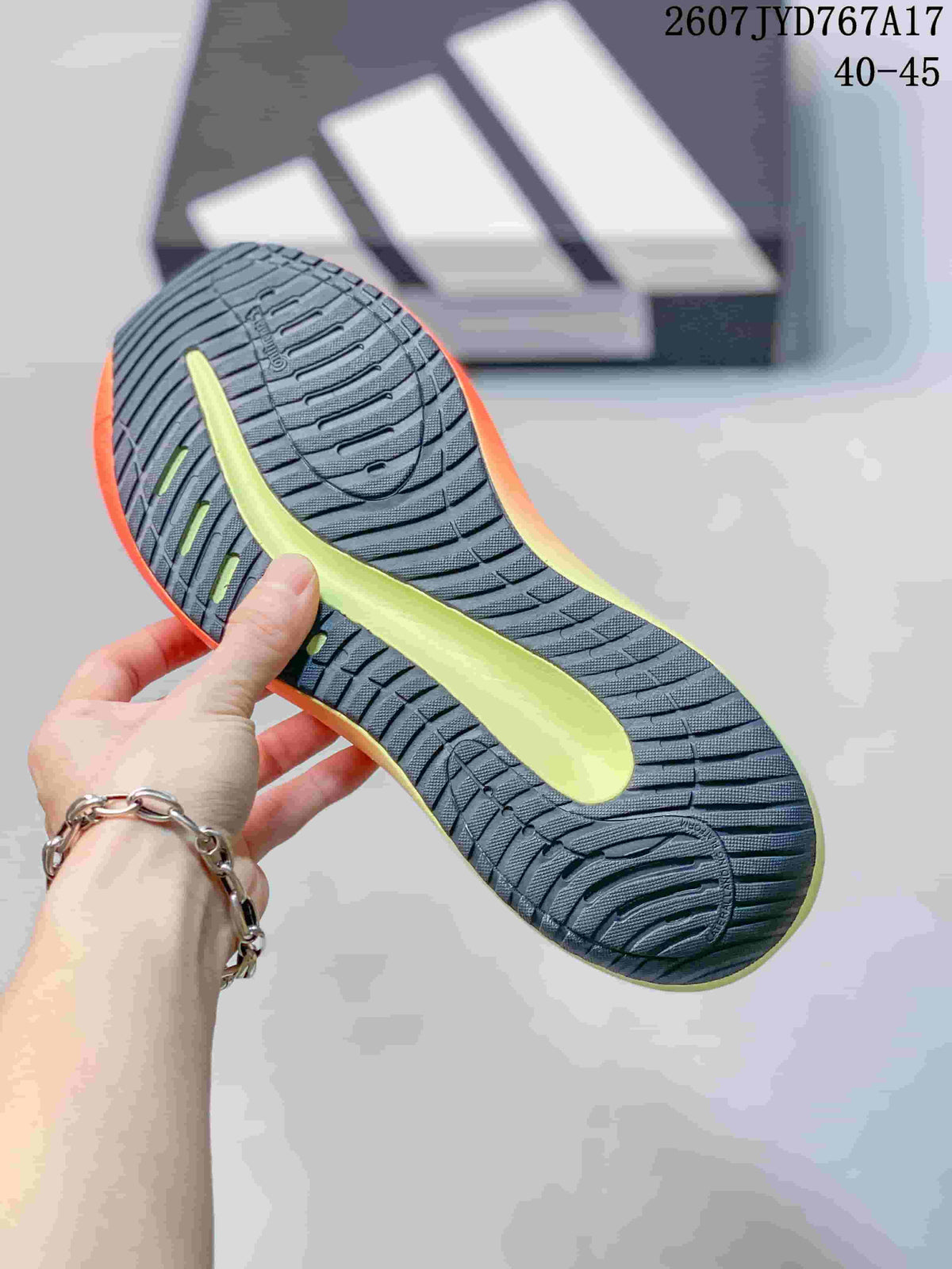 Close view of the patterned outsole of an Adidas Supernova Rise sneaker, showing dark rubber tread and a lime-green central section; image text shows size range 40–45.