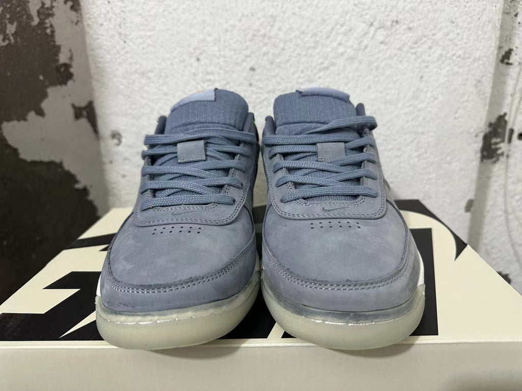 Front view of blue-gray Nike Book 1 shoes with laces and perforated toe panels
