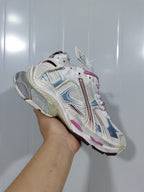 Close angled view of the Balenciaga Runner 3120 sneaker showing the white upper, burgundy and blue detailing, pink accents, and sculpted outsole.