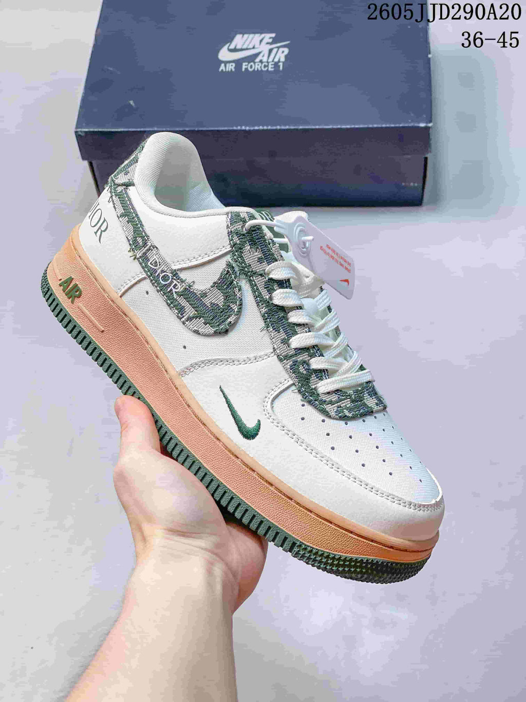 White low-top sneaker with green patterned accents and a peach-colored midsole