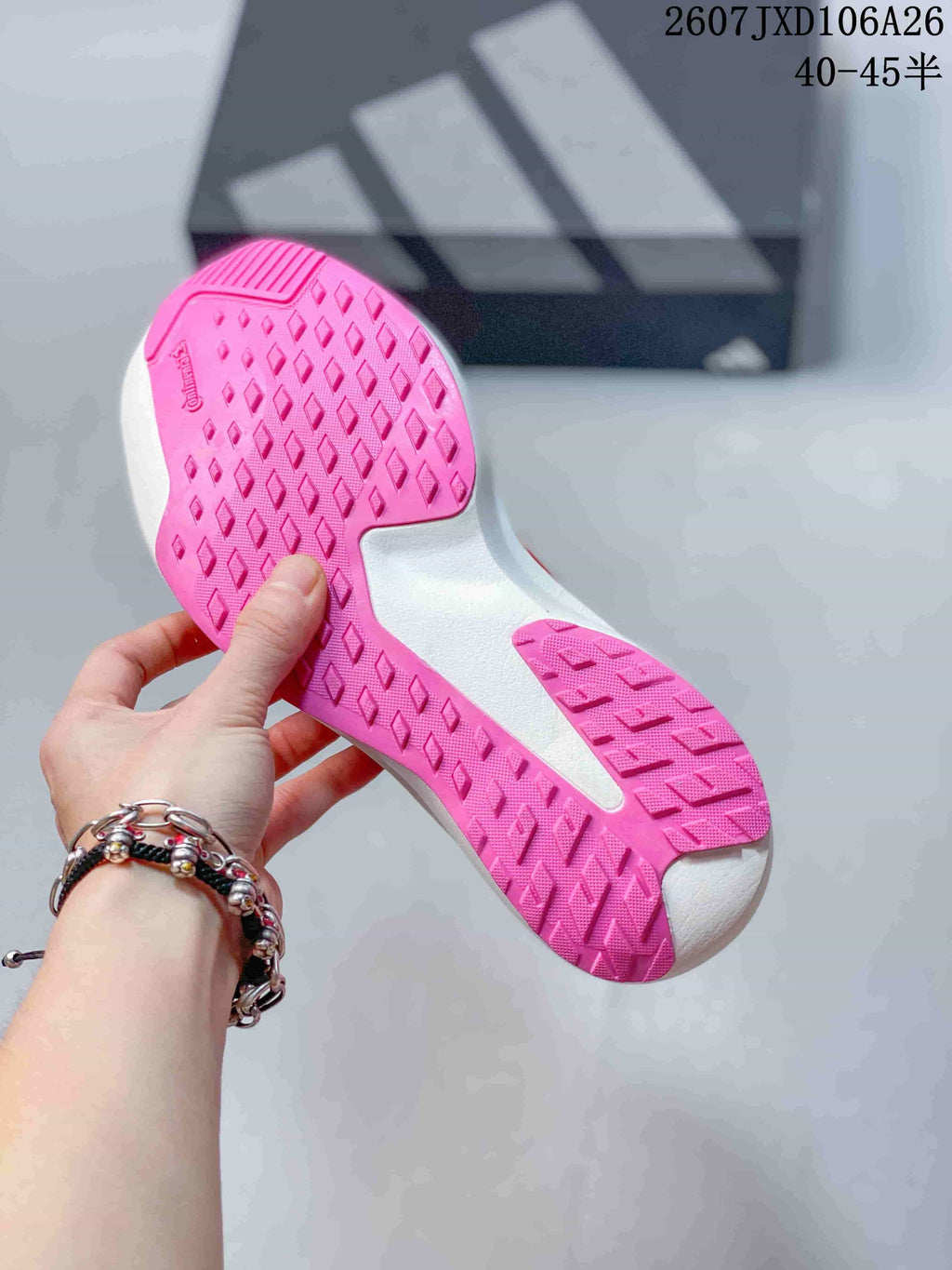 Underside of the shoe showing the pink rubber outsole with diamond-shaped traction details.
