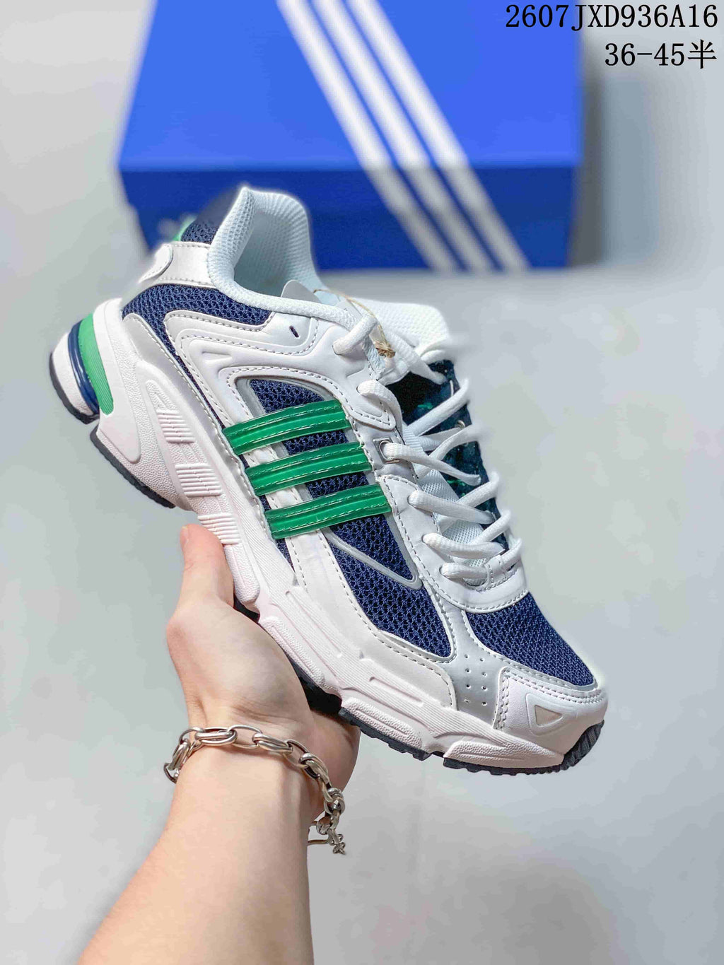 White and navy adidas Response CL sneaker with bright green side stripes, shown against a blue shoe box.