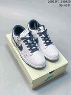 Pair of off-white and black Nike SB Dunk Low sneakers with dark laces and contrasting side branding.