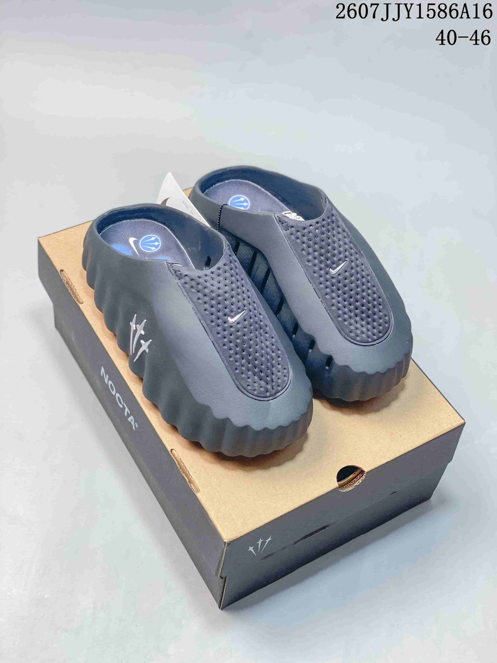 Black and gray source-identified Nike Mind 001 closed-toe slides displayed on a shoe box; image text shows style code 2607JJY1586A16 and size range 40–46.