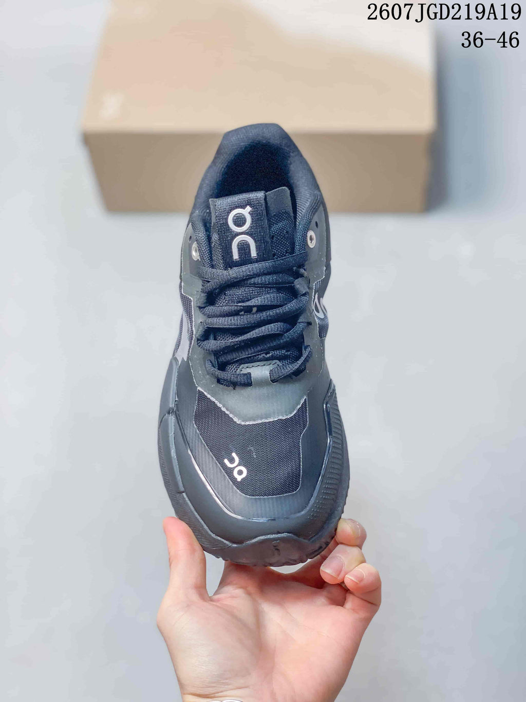 Top view of the black lace-up tennis shoe showing the tongue, eyelets and layered toe area.