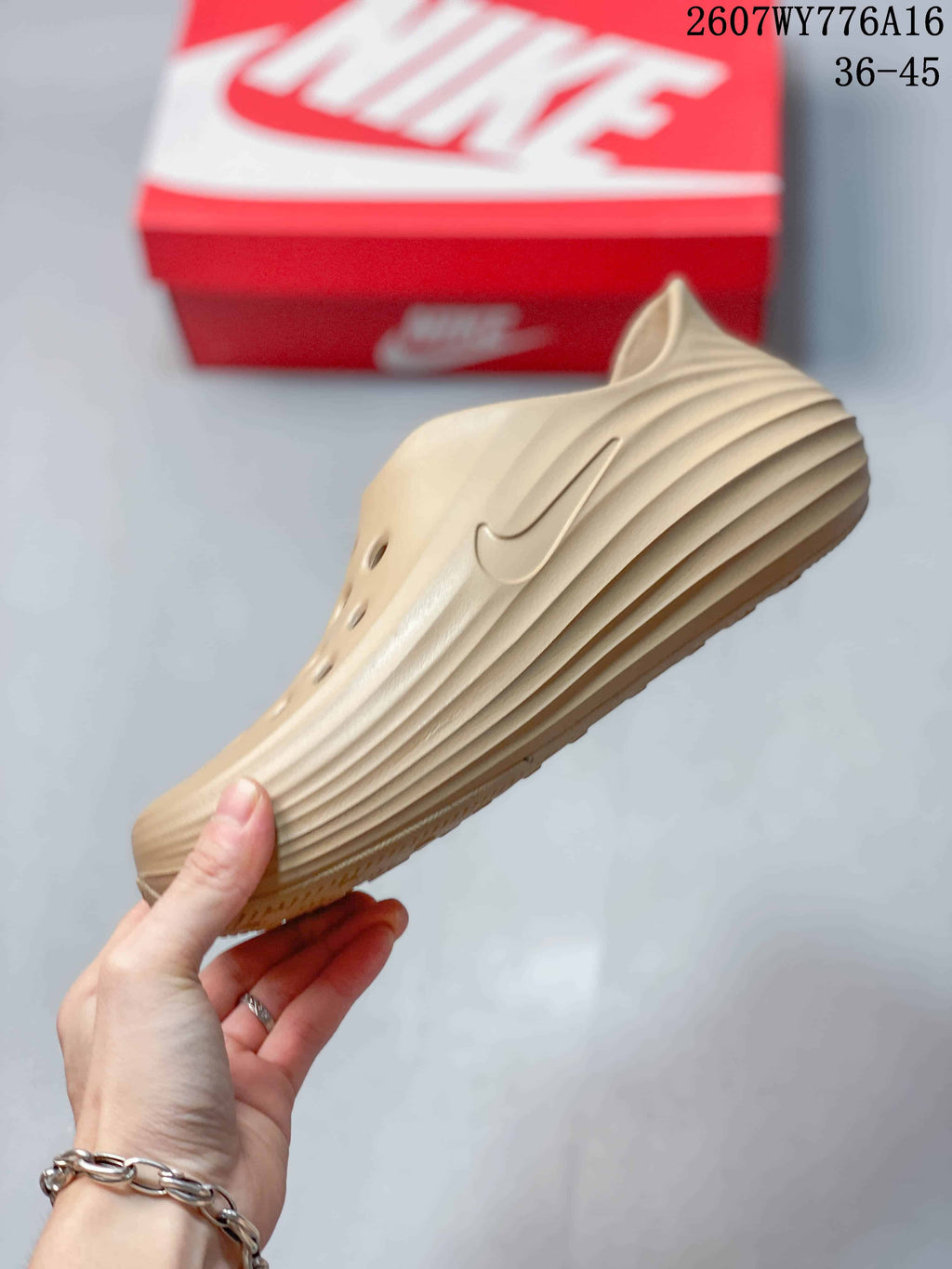 Side profile of the tan clog showing the perforated upper, Nike Swoosh detail, and layered side ridges.