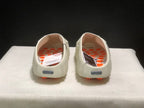 Rear view of the pair showing the open-back mule shape, textured insoles, and orange outsole pods.