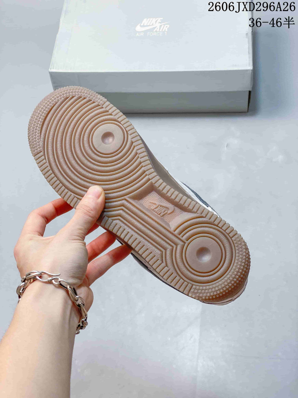 Underside of a sneaker showing a gum-tone outsole with circular tread patterns