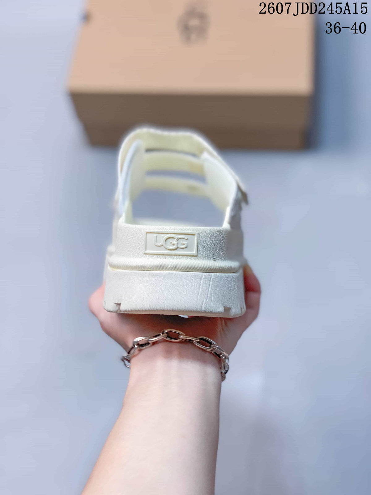 Rear view of the white slide sandal showing the heel strap, raised UGG logo, and thick sole.