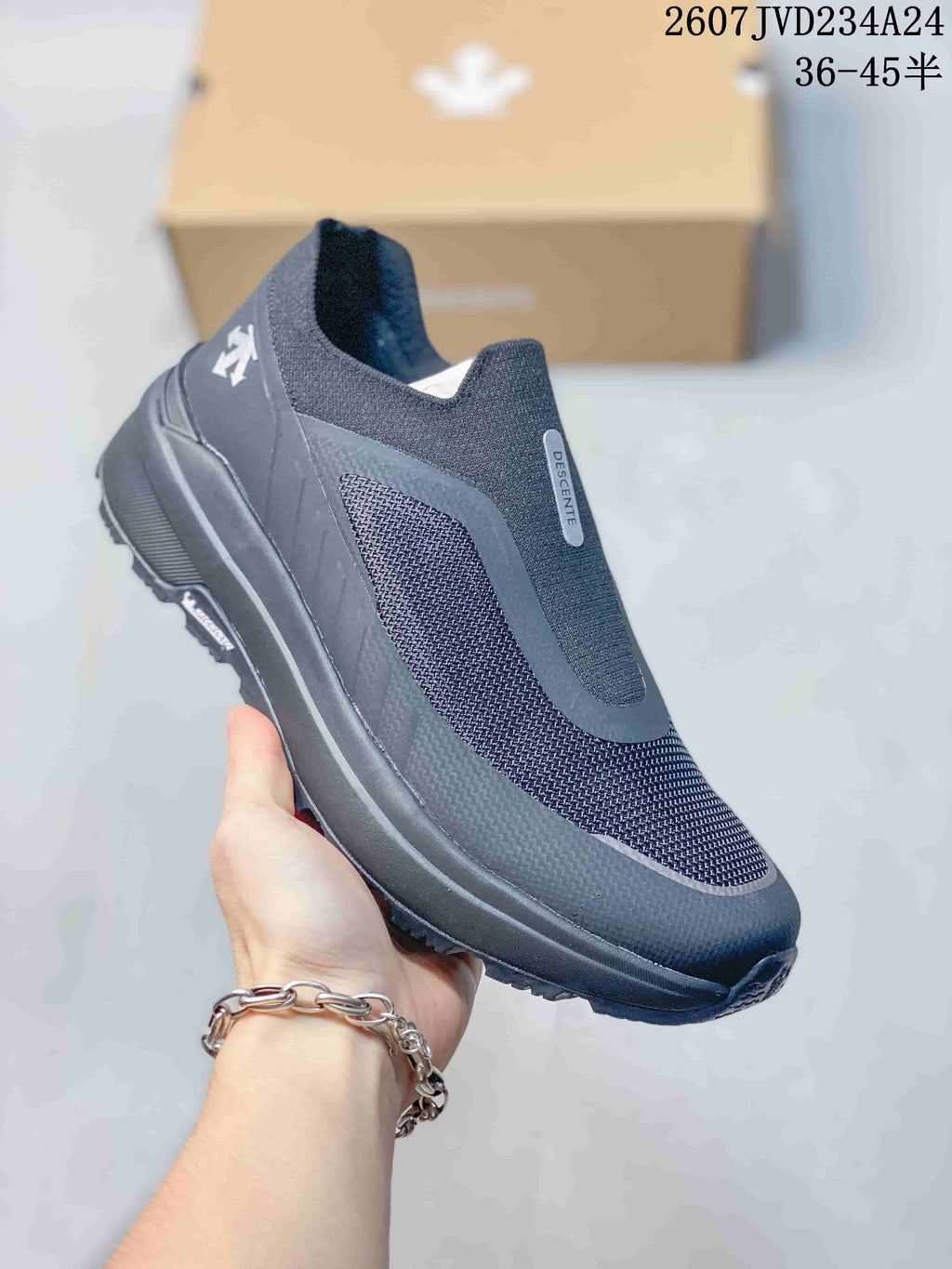 Angled side view showing the dark gray slip-on upper, mesh-like side panel, heel branding, and treaded sole.