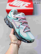 Angled side view of the Nike V5 RNR sneaker showing layered mint and white panels, pink laces, Nike branding and the dark outsole.