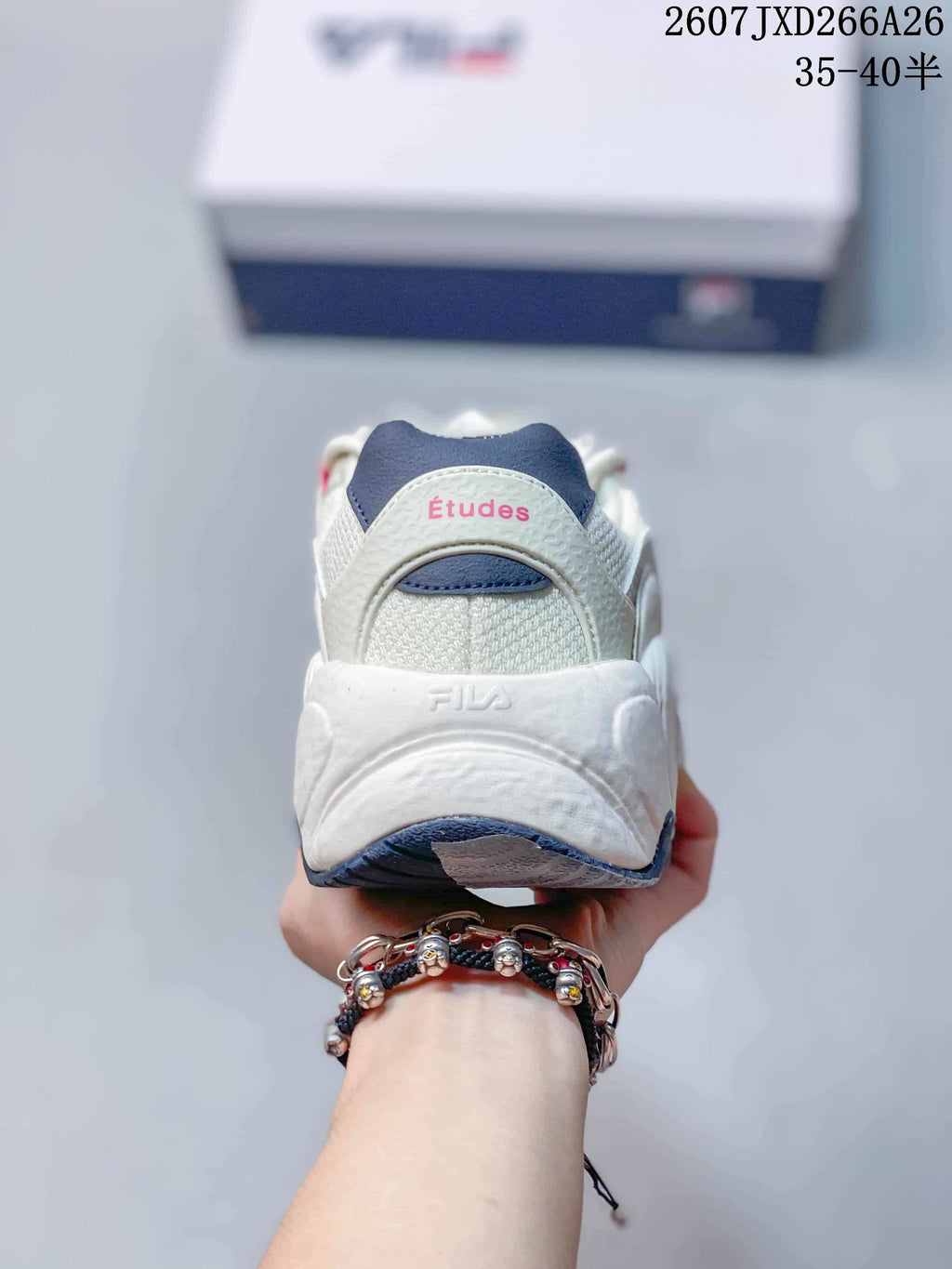 Rear view of the sneaker showing the padded heel, navy heel detail, FILA branding, and pink Études text.