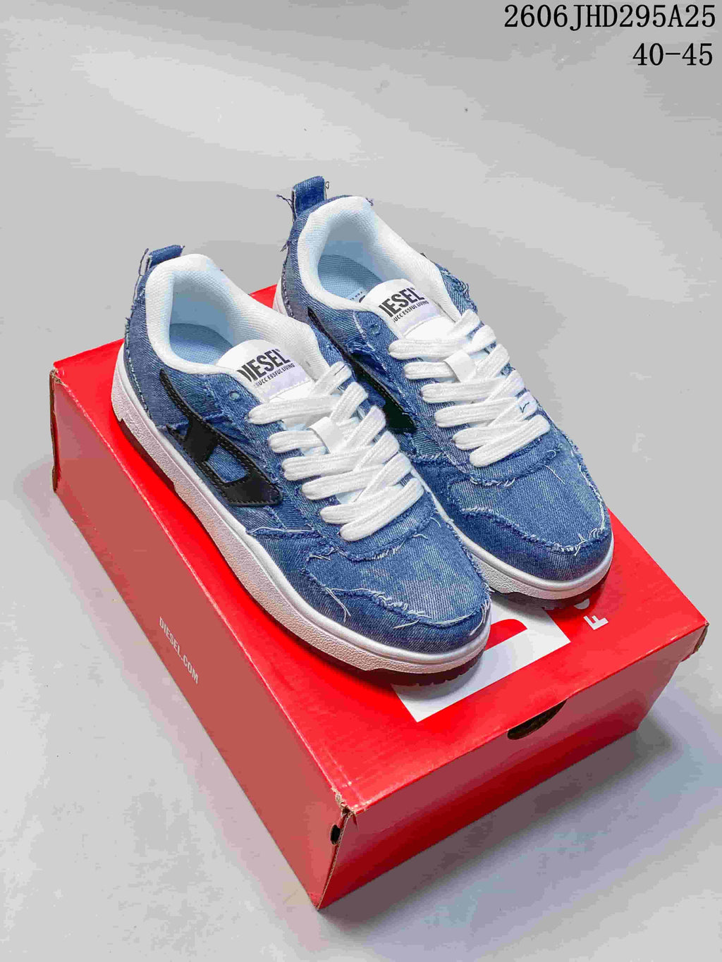 Pair of blue denim-look Diesel S-ukiyo V2 sneakers with white laces and white midsoles, shown on a red shoe box.