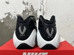 Rear view of black sneakers with white embroidered heel details and sculpted white midsoles.