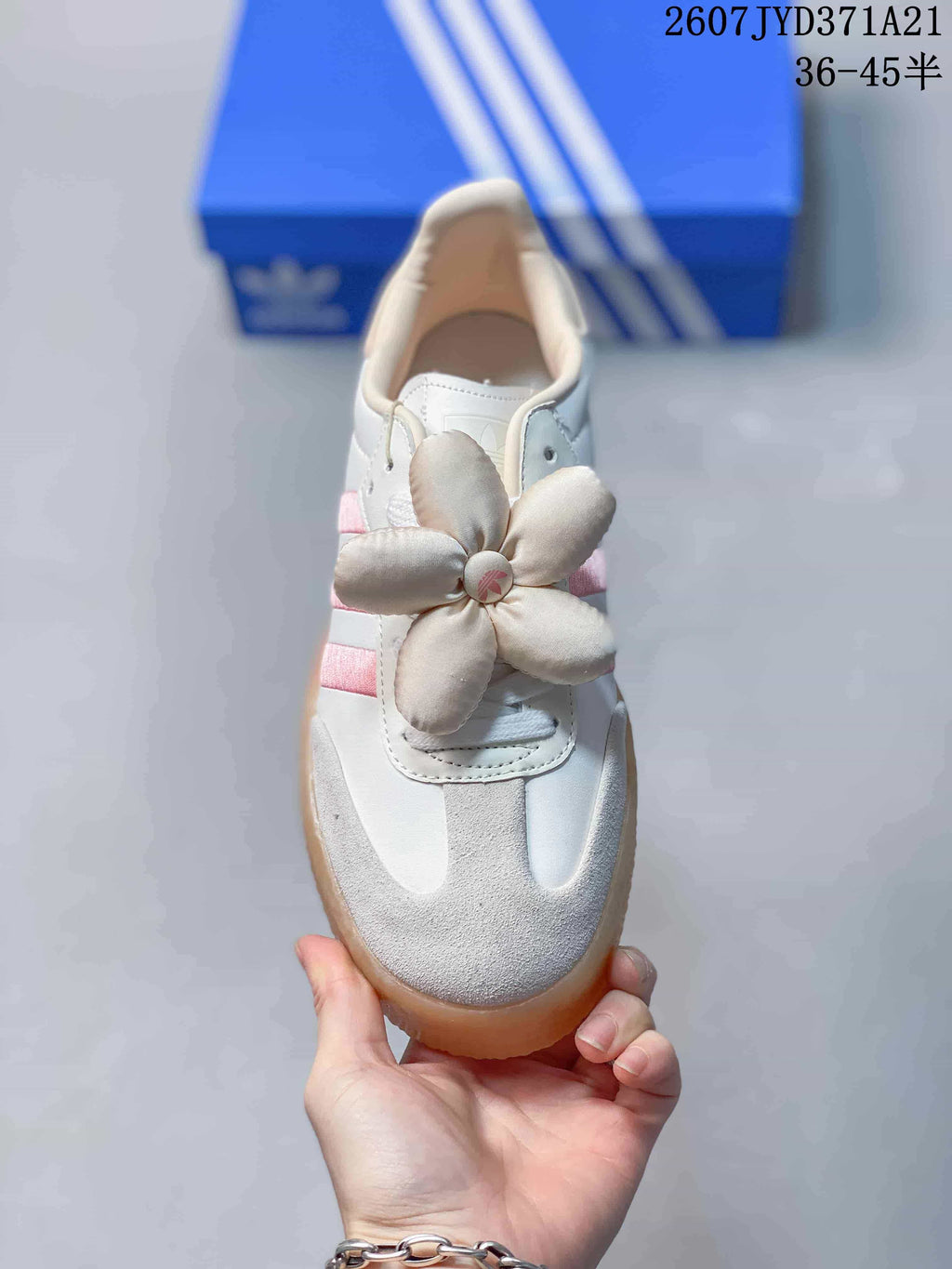 Top view showing the white and pink sneaker, suede-look toe panels, laces, and flower decoration.