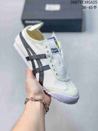 White Onitsuka Tiger slip-on sneaker with black side stripes and a white outsole.