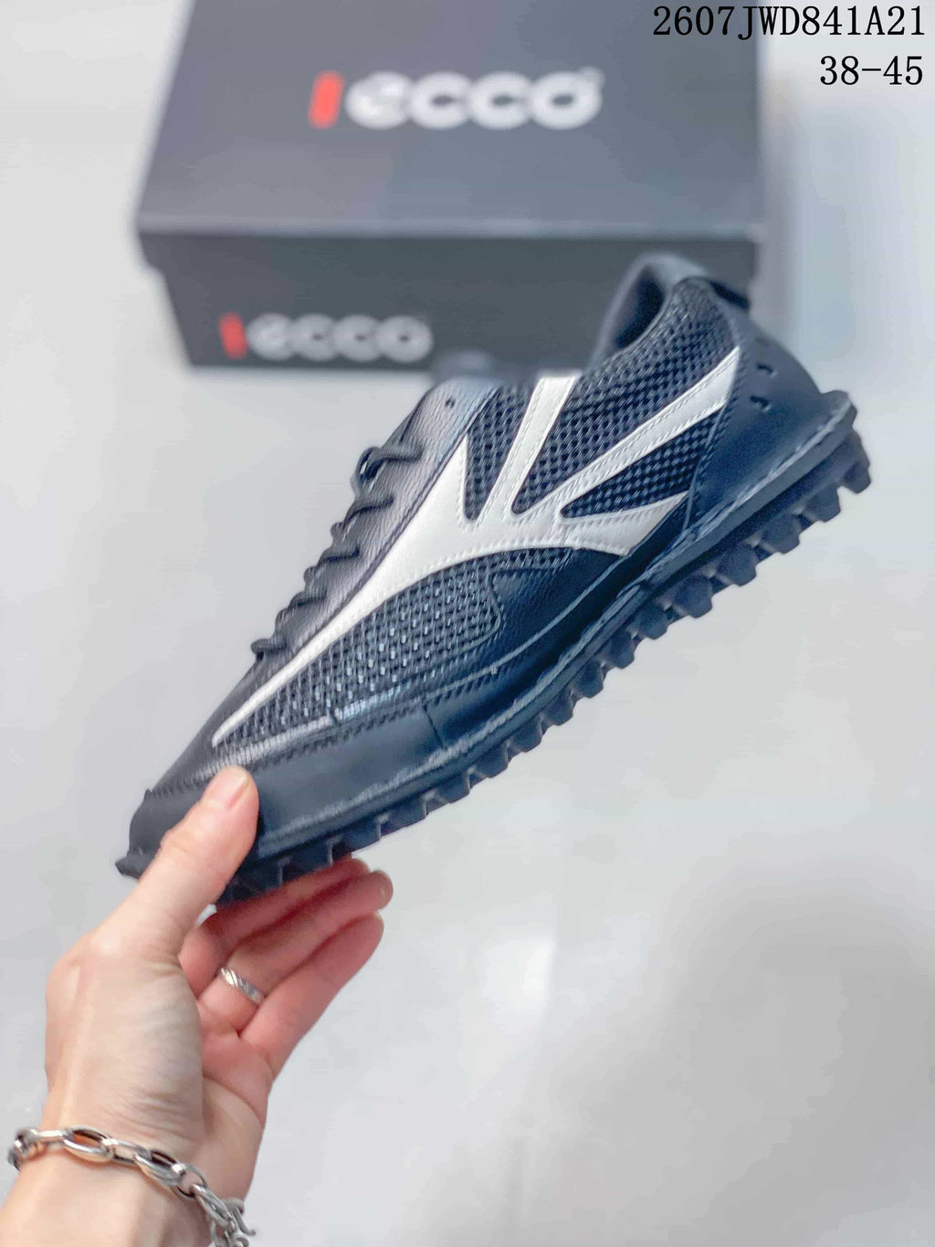 Side view of the black and white sneaker showing mesh panels, contrasting overlays and the raised outsole.