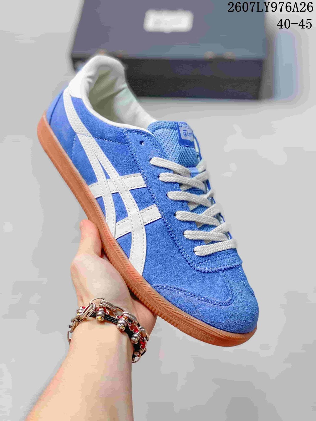 Angled side view of the blue and white lace-up sneaker with contrasting stripes and gum-colored sole.