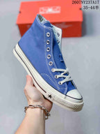 Angled side view of the blue Converse high-top sneaker with white laces, rubber toe cap, and textured sole.