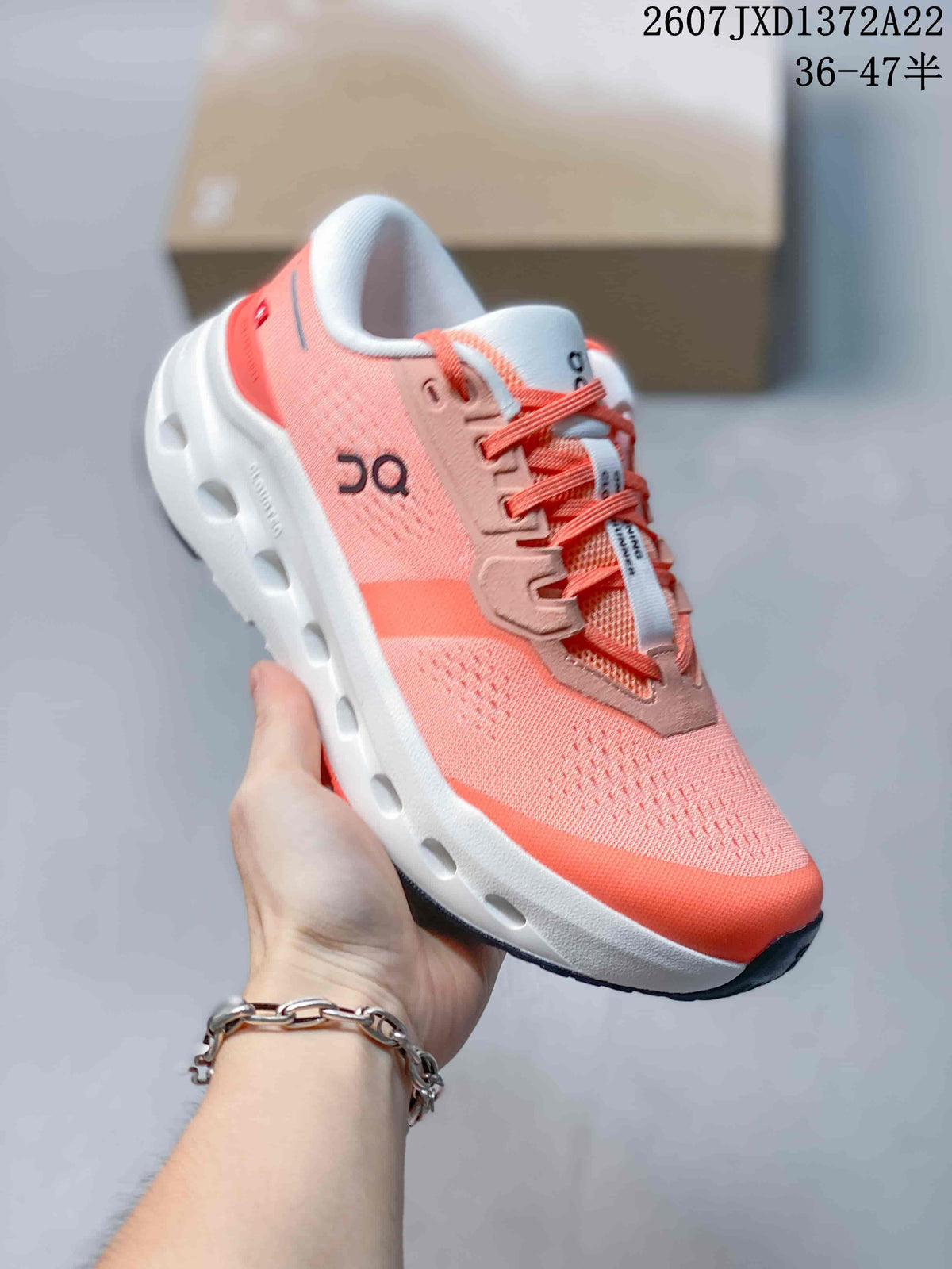 Angled side view of a coral and white On Cloudrunner 3 sneaker showing the upper, laces, side branding, and outsole openings.