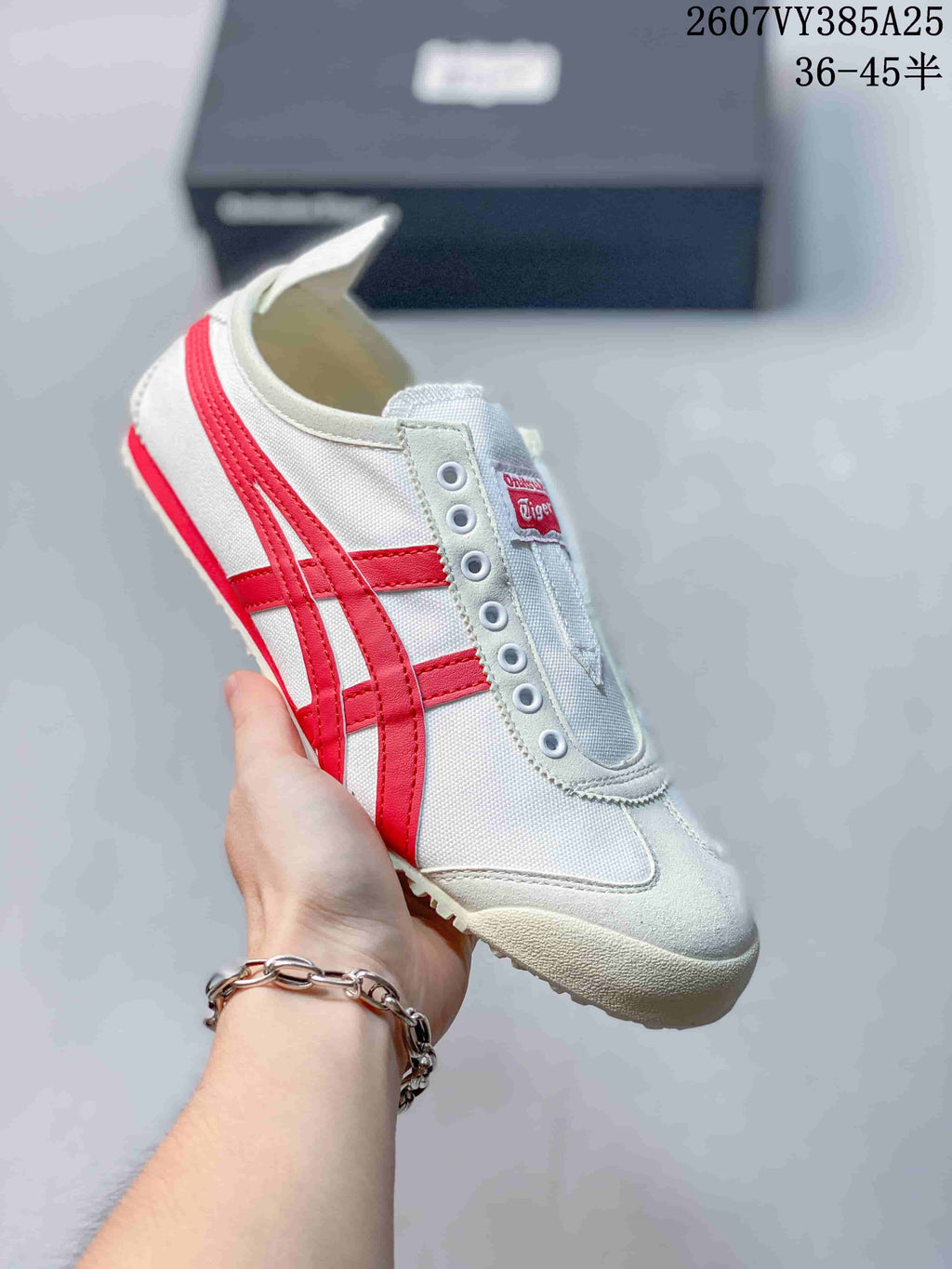 White slip-on sneaker with bright red side stripes and a light-colored outsole.
