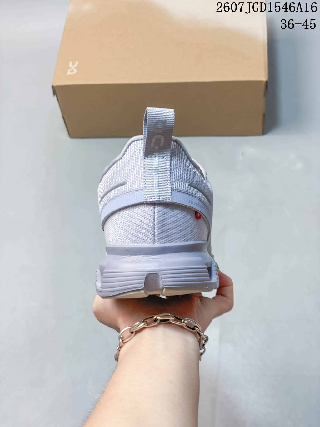 Rear view of the light gray sneaker showing the heel pull tab, padded collar and layered heel construction.
