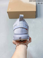 Rear view of the light gray sneaker showing the heel pull tab, padded collar and layered heel construction.