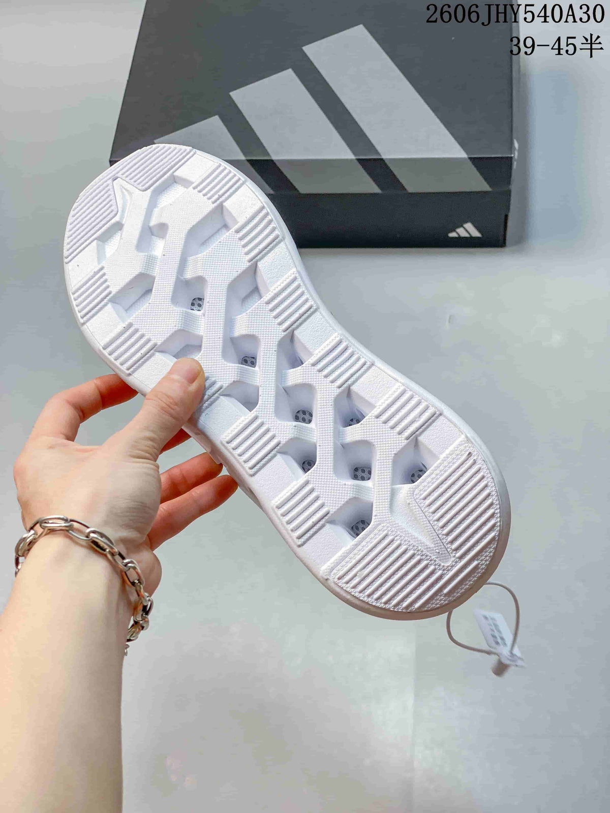 Underside of the shoe showing the white outsole and its segmented tread.
