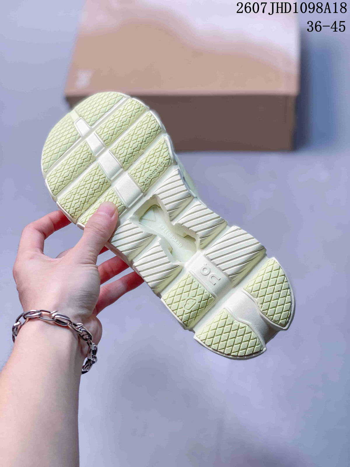 Outsole view of a pale green sneaker showing the segmented tread pattern and raised midsole structure.