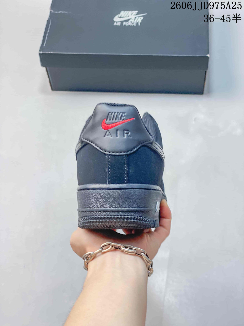 Rear view of a black Nike Air Force 1 sneaker showing the heel branding, padded collar, and layered outsole.