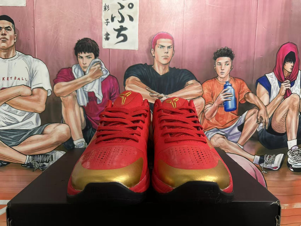 Front view of red lace-up basketball shoes with gold toe accents