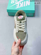 Top view showing the laces, perforated muted green toe panel, and padded tongue.