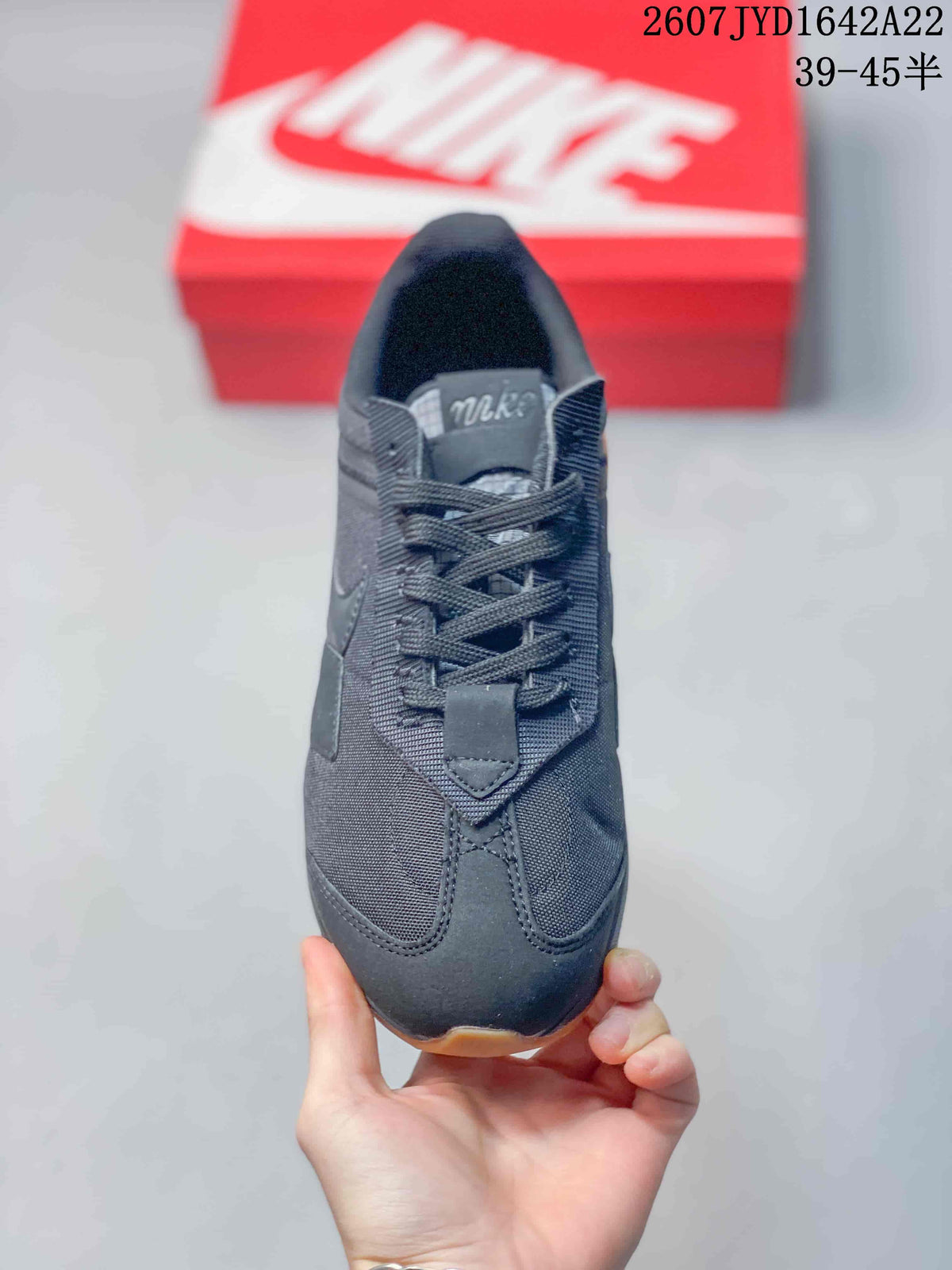 Top view of the black sneaker showing the lace-up construction, padded collar and layered toe panels.