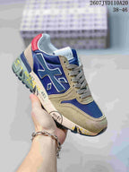 Navy Premiata sneaker with beige overlays, gray laces, and a red heel accent.