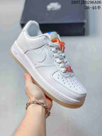 Three-quarter side view of the white low-top sneaker with Swoosh branding, orange and yellow accents, and translucent gum-colored outsole.