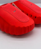 Close-up of the perforated footbed and small Swoosh detail on an orange-red slide.