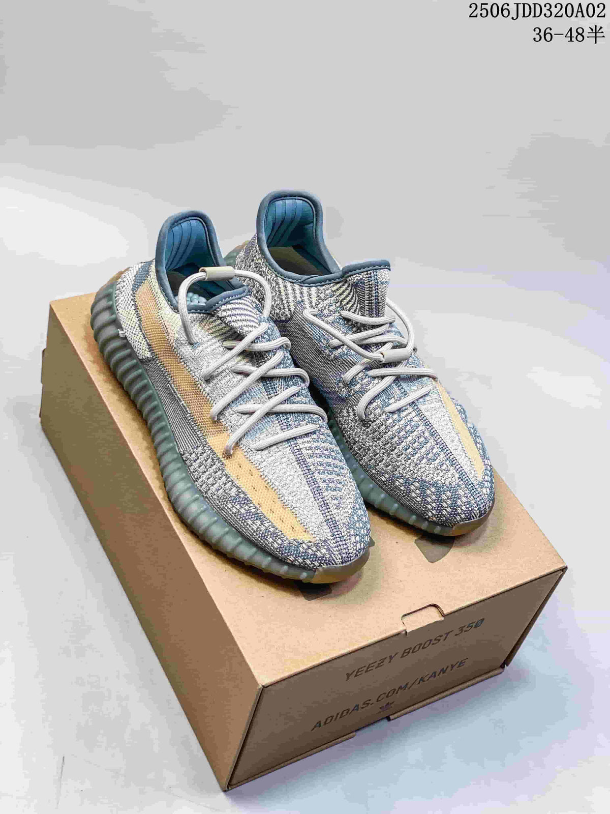 Pair of grey and tan Adidas Yeezy Boost 350-style sneakers displayed on a shoebox.