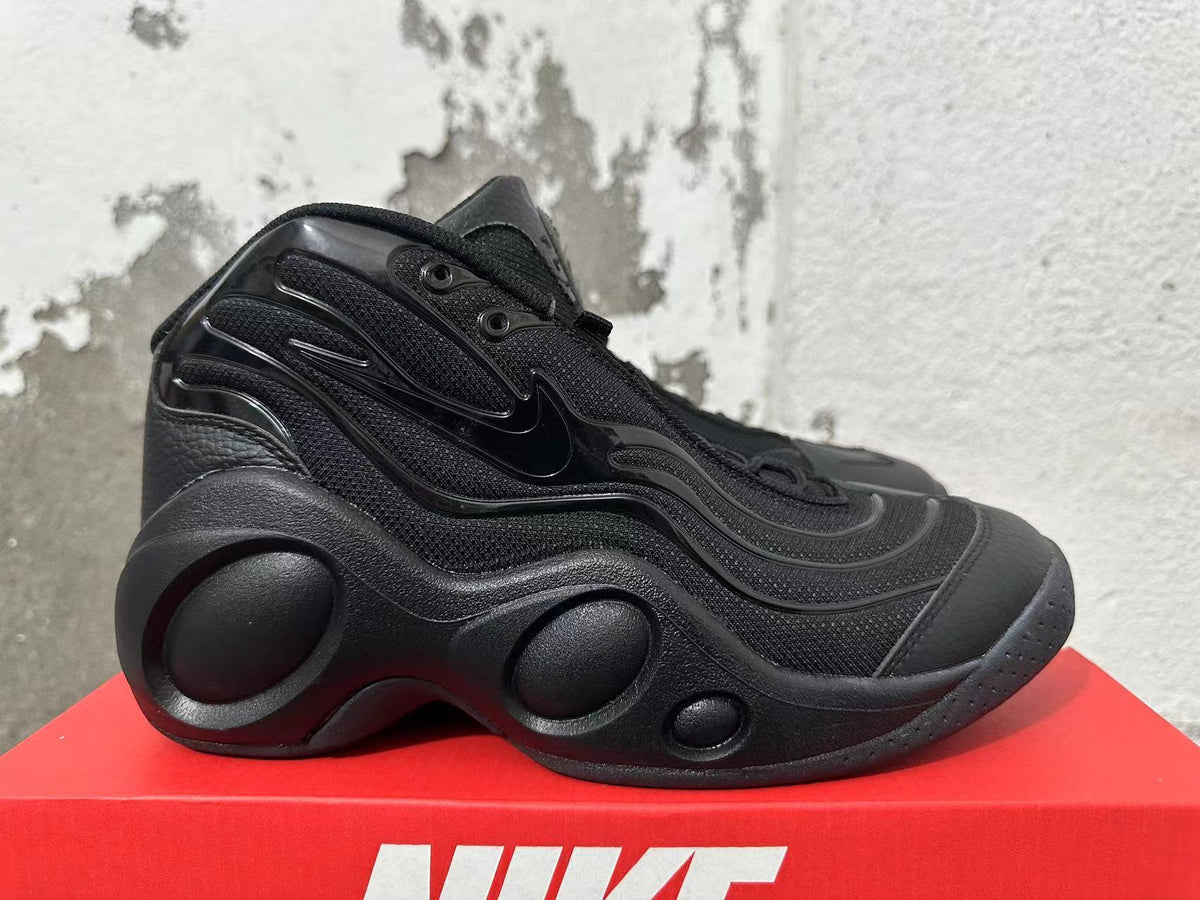 Side profile of a black Nike sneaker with molded side panels and a sculpted sole.