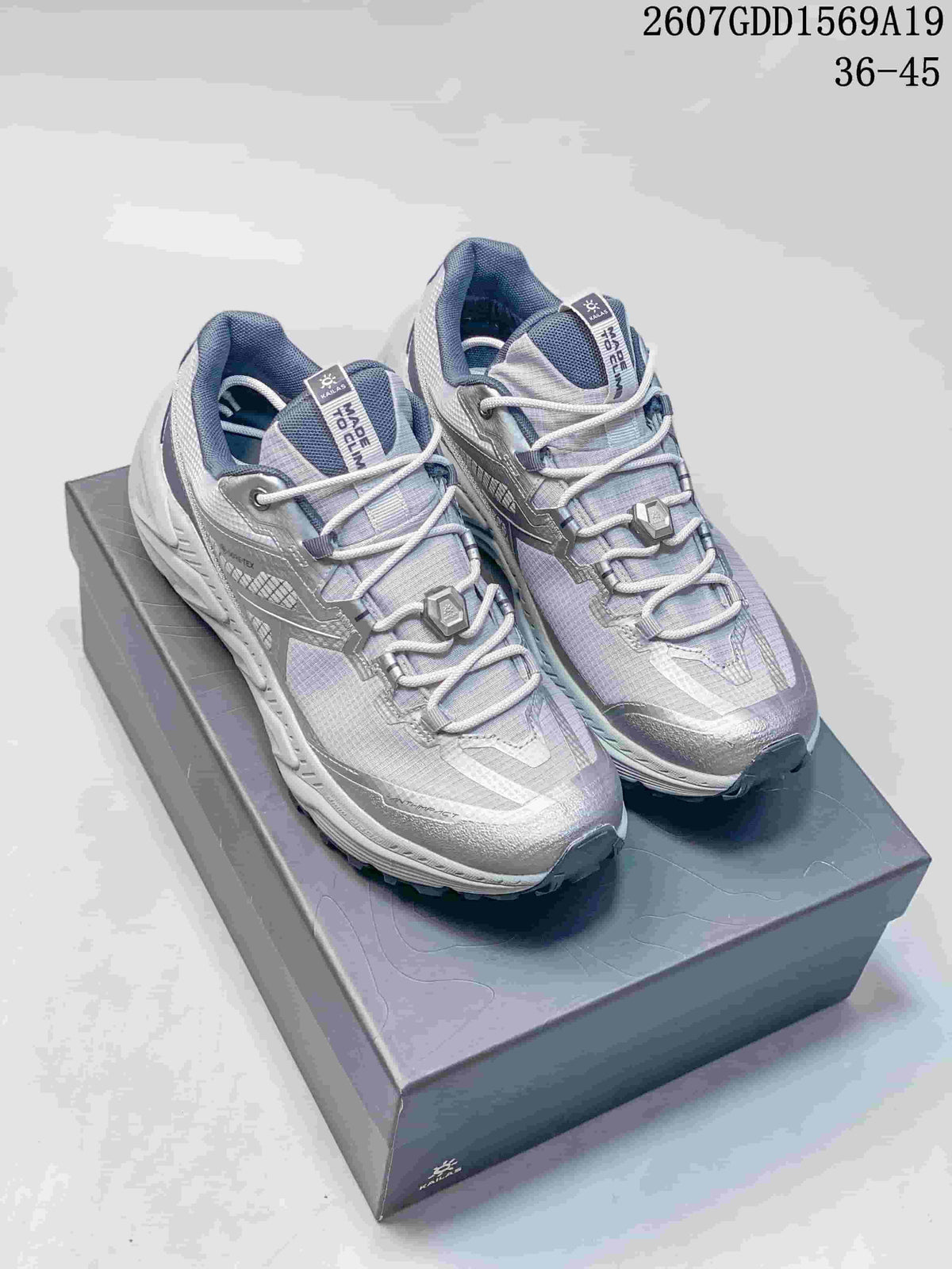 Pair of light gray and lavender-toned KAILAS trail shoes displayed on a shoebox.